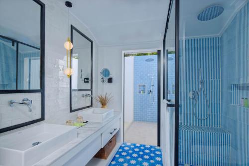 a bathroom with a shower, sink, and tub at Sun Island Resort & Spa in Maamigili