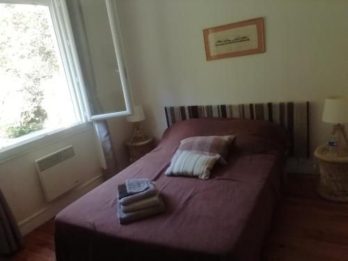 a bedroom with a bed with two towels on it at Maison de village en bord de rivière in Narcy