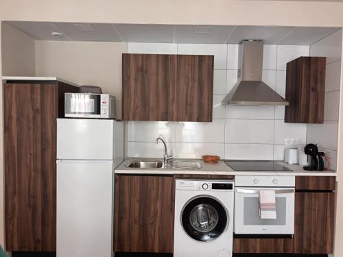 a kitchen with a white refrigerator and a washing machine at La Casona del Eboni in Alcalá de Henares