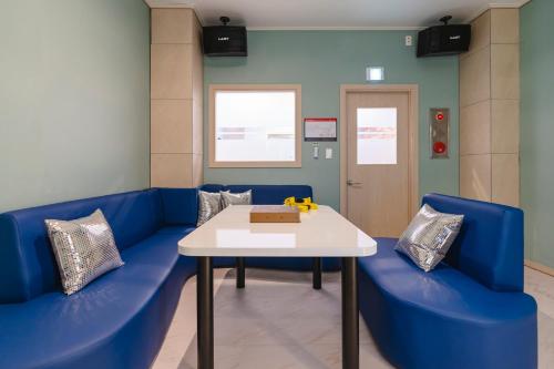 a waiting room with a blue couch and a table at Hallim Resort in Jeju