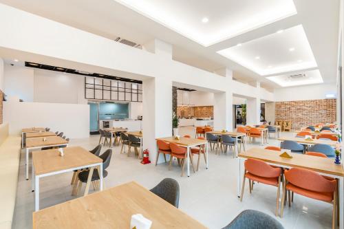 a restaurant with wooden tables and chairs and tablesktop at Hallim Resort in Jeju