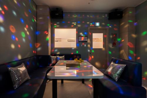 a room with a table and couches and a screen at Hallim Resort in Jeju