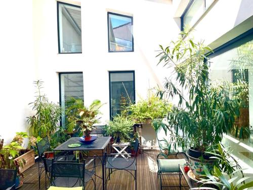 un patio avec des plantes et une table et des chaises dans l'établissement Patio 3 Pézenas CENTRE il y a plus cher mais c est moins bien, à Pézenas