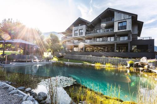 a building with a pond in front of it at THE MATTHEW - Copper Lodge in Wagrain