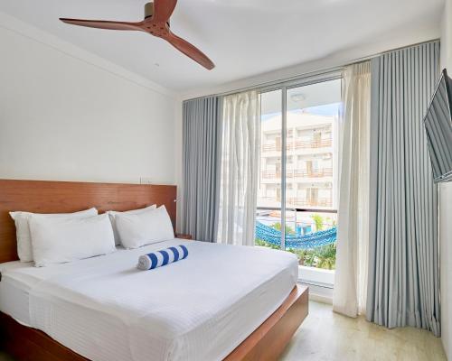 1 dormitorio con cama y ventana grande en Bliss Dhigurah, en Dhigurah