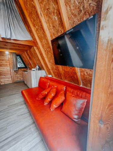 a red couch in a room with a flat screen tv at Layali Al Shams Hotel in ‘Anjar
