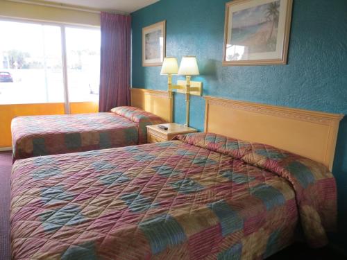 a hotel room with two beds and a window at Skyway Motel in Daytona Beach