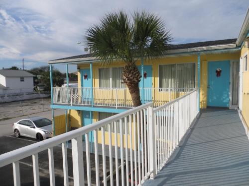 a yellow house with a palm tree in front of it at Skyway Motel in Daytona Beach