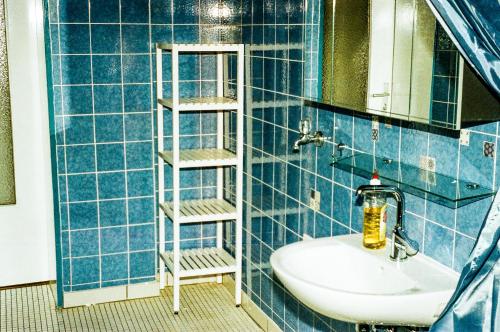 ein blau gefliestes Bad mit einem Waschbecken und einem Spiegel in der Unterkunft LIVING SPACE in Herne