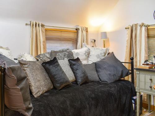 a couch with pillows on it in a living room at Cobblers Cottage in Saint Dennis