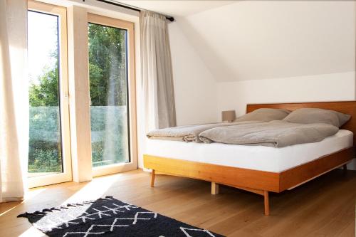 Un dormitorio con una cama y una ventana grande. en Waldhäusl am Donaudurchbruch, en Kelheim