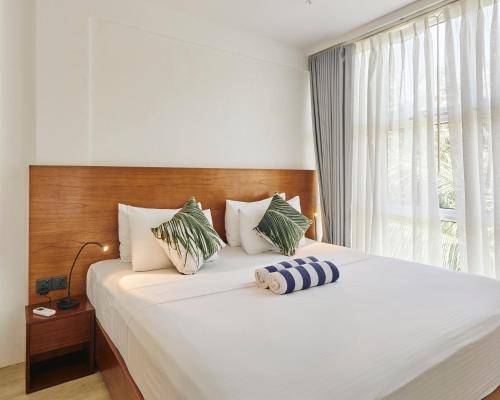 a bedroom with a large white bed with a window at Bliss Dhigurah in Dhigurah