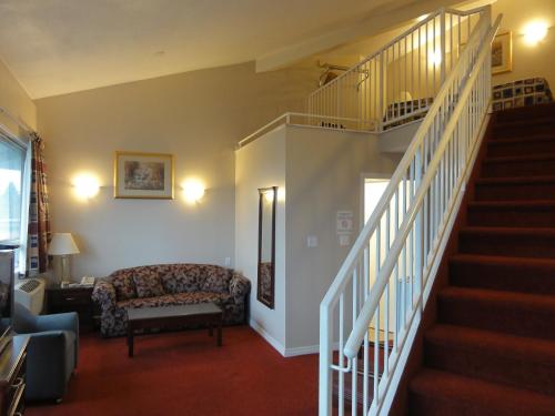 a living room with a staircase and a couch at Port Augusta Inn in Comox