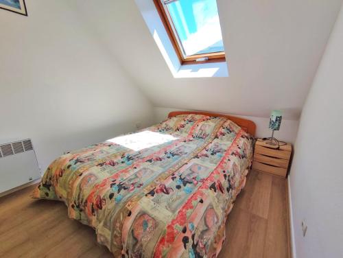 a bedroom with a bed with a comforter and a window at Le Marmandais, T3 lumineux, balcon, parking, wifi, proche thermes, 4 personnes in Luchon