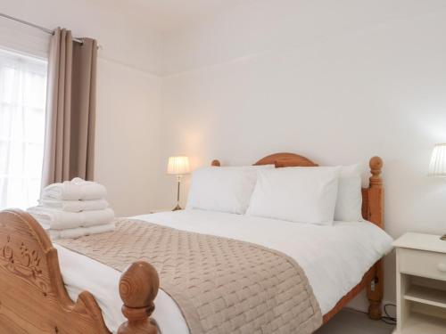 Schlafzimmer mit einem Bett mit weißer Bettwäsche und einem Fenster in der Unterkunft St Botolphs in Hornsea