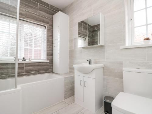 ein weißes Badezimmer mit einer Badewanne und einem Waschbecken in der Unterkunft St Botolphs in Hornsea
