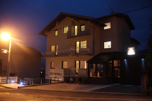 a tall building at night with a street light at Apartmani i Bungalovi TROJKA in Banja Luka