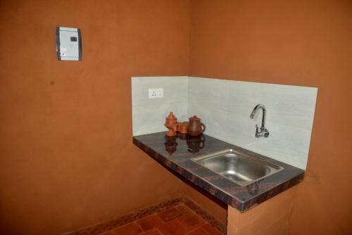 a bathroom with a sink in a room at Kudil Mud Cottages, Cheemeni in Peringom