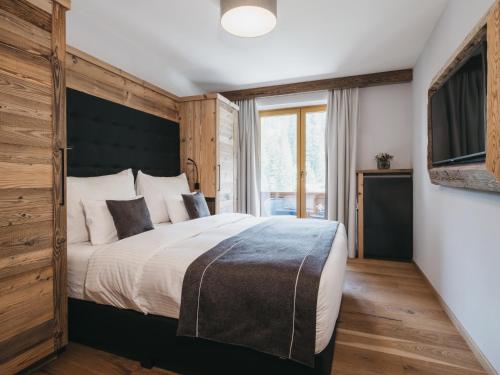 a bedroom with a large bed with a black headboard at VAYA Gerlos in Gerlos