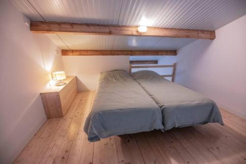 a bedroom with a bed and a wooden floor at 't Pekelhuis - Vakantiehuisje op boerderij Huize Blokland in Hem