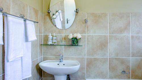 a bathroom with a sink and a mirror at Beautiful 2 bedroom Apartment near Monte Casino in Sandton