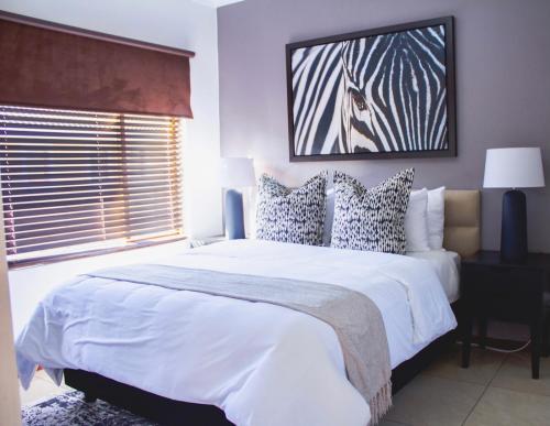 a bedroom with a large white bed and a window at Beautiful 2 bedroom Apartment near Monte Casino in Sandton