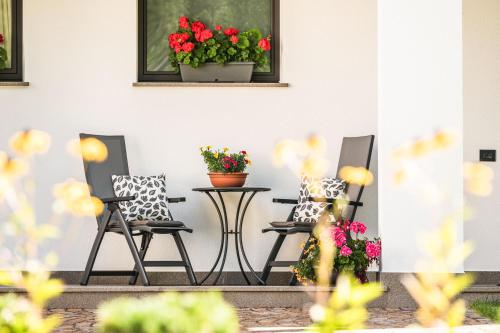 a patio with two chairs and a table with flowers at Chalet Miriam in Selva di Val Gardena