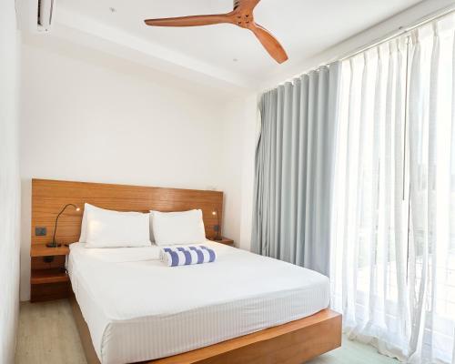 a bedroom with a bed and a dresser at Bliss Dhigurah in Dhigurah