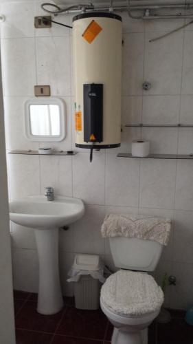 a small bathroom with a toilet and a sink at JMJ Departamentos Amoblados Ocarrol in Rancagua