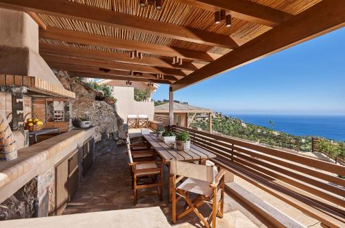 un patio con mesa, sillas y el océano en Villa Omikron, en Rodhiá
