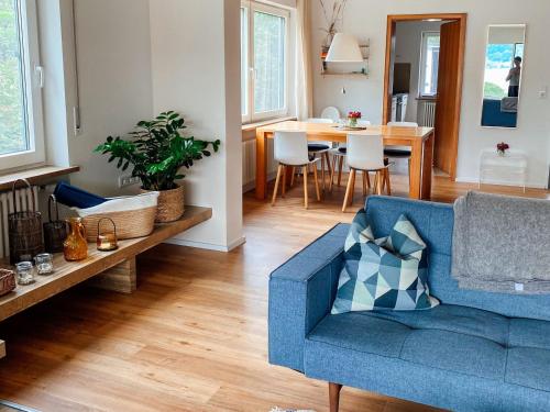 - un salon avec un canapé bleu et une table dans l'établissement Ferienwohnung Findling, à Île de Reichenau
