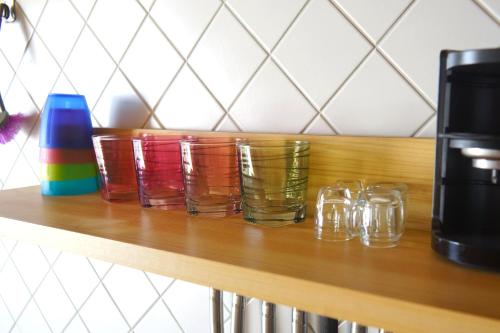 a group of glasses sitting on a wooden shelf at FEWO Blick Falkenstein in Pfronten