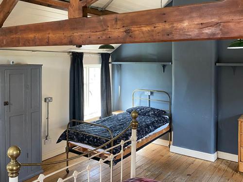 1 dormitorio con litera en una habitación con paredes azules en Southfield Art Studio, en Braunston