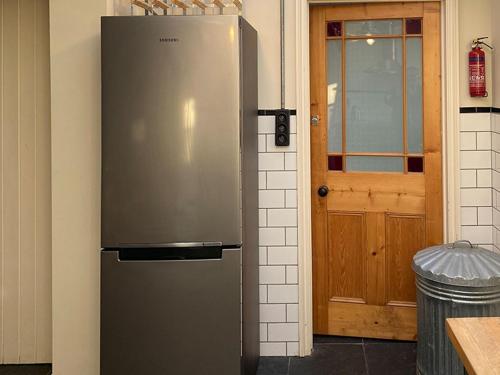 a stainless steel refrigerator in a kitchen with a door at Southfield Art Studio in Braunston