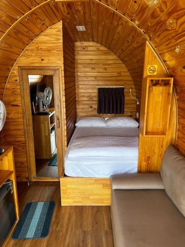 a small bedroom with a bed in a wooden cabin at HB Bungalow in Da Lat