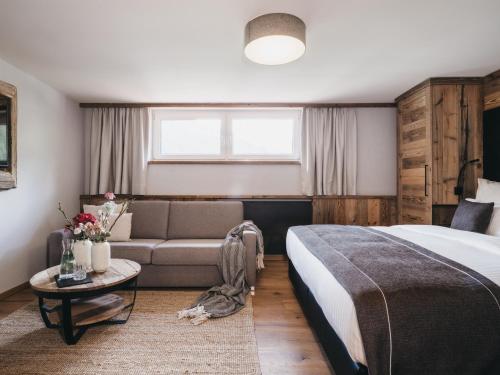 a hotel room with a bed and a couch at VAYA Gerlos in Gerlos