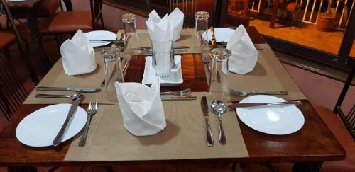 una mesa de madera con platos blancos y cubiertos en Sochati Casa Resort, en Nairobi