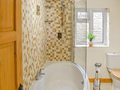 La salle de bains est pourvue d'une baignoire blanche et d'une fenêtre. dans l'établissement Greenview, à Nawton