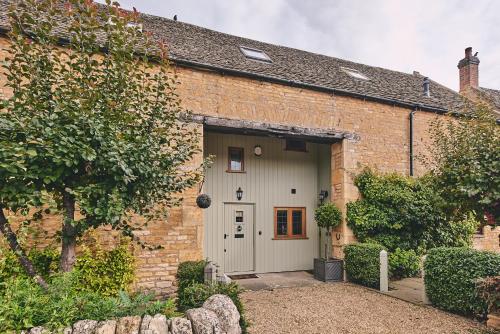 a brick building with a garage with a door at Squirrel Barn in Moreton in Marsh