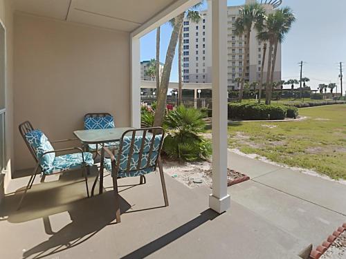a porch with a table and chairs and a building at Grand Caribbean Perdido Key #114 West in Perdido Key