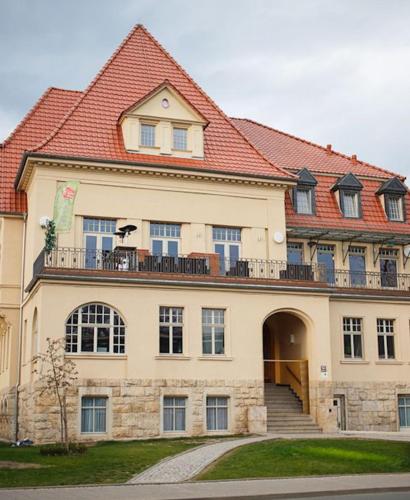 une grande maison avec un grand toit rouge dans l'établissement Hotel Villa am Paradies, à Iéna