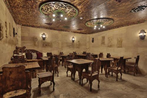 a room with tables and chairs and a couch at Old Town Stone House in Goreme