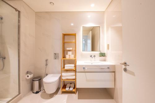 uma casa de banho com um lavatório, um WC e um chuveiro em Stunning 1BR Apt high floor with palm view & private beach at EMAAR Beachfront em Dubai