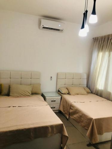 two beds sitting next to each other in a room at Lovely penthouse 4- bedroom directly on the lagoon in El Alamein