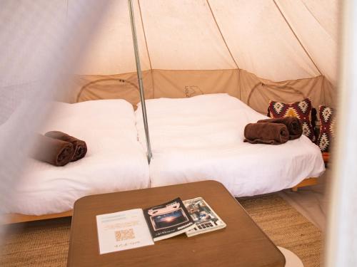 a room with two beds in a tent with a table at Dot Glamping 富士山 in Fujikawaguchiko