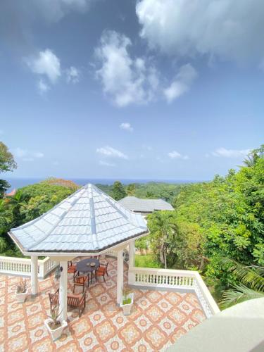 a gazebo with a table and chairs on a patio at All Nations Guest House in Port Antonio