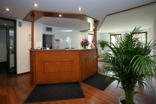 a lobby with a reception desk and plants at Hotel Sophienhof in Königs Wusterhausen