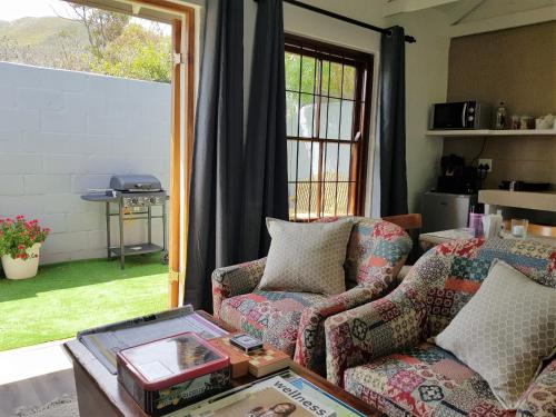a living room with a couch and a chair at Hemel en Aarde Village Accommodation in Hermanus