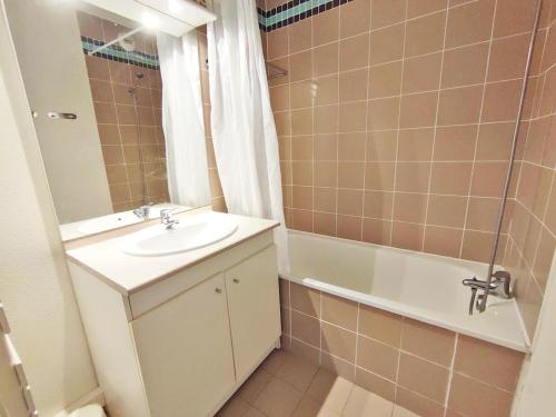a bathroom with a sink and a bath tub at Le Flocon, T2, vue montagne, parking gratuit, 4 personnes in Luchon