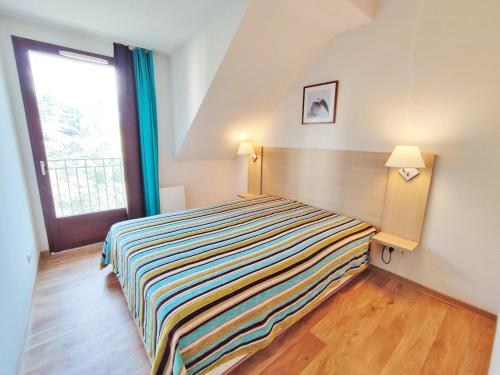 een slaapkamer met een bed en een groot raam bij Le Flocon, T2, vue montagne, parking gratuit, 4 personnes in Luchon